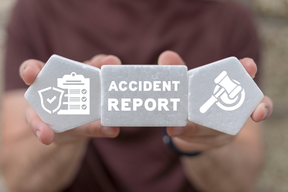 Person holding blocks with icons for insurance, accident report, and legal representation in their hands.